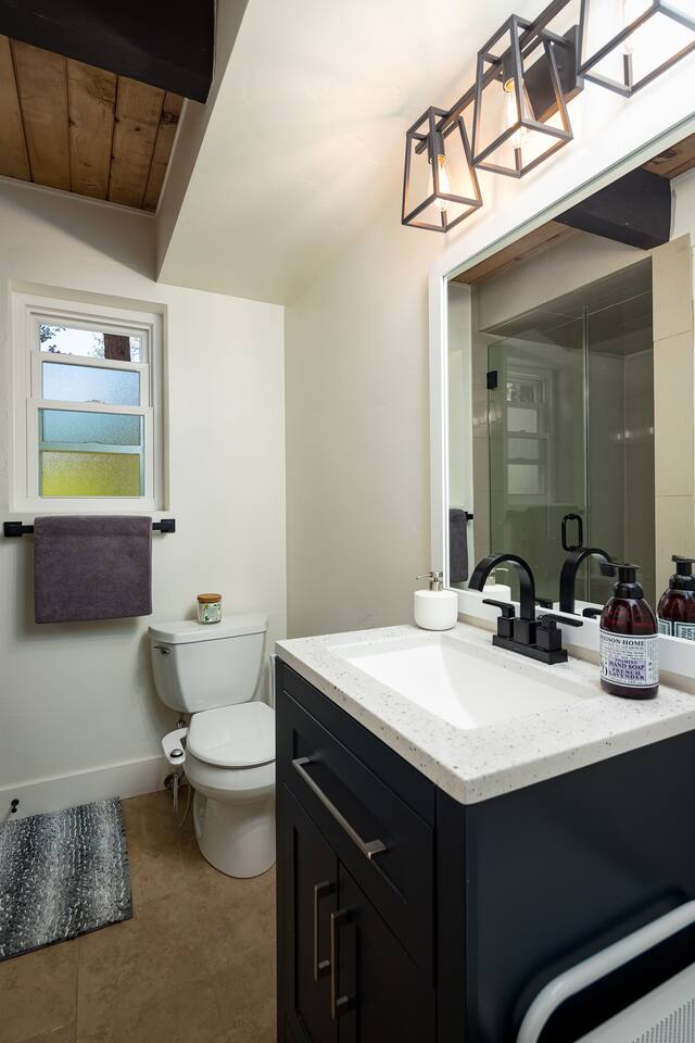 Second bath has a large tile shower, a bidet, and  lots of storage.  A hairdryer and makeup mirror are provided, along with towels, washcloths, and hand towels.