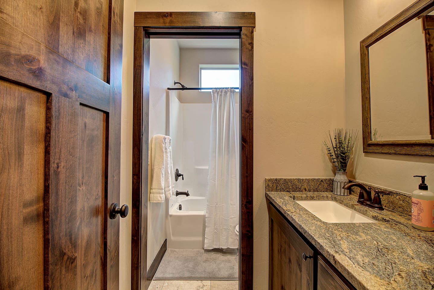 Fresh towels, warm lighting, and a granite vanity make this bathroom feel like a little retreat of its own.