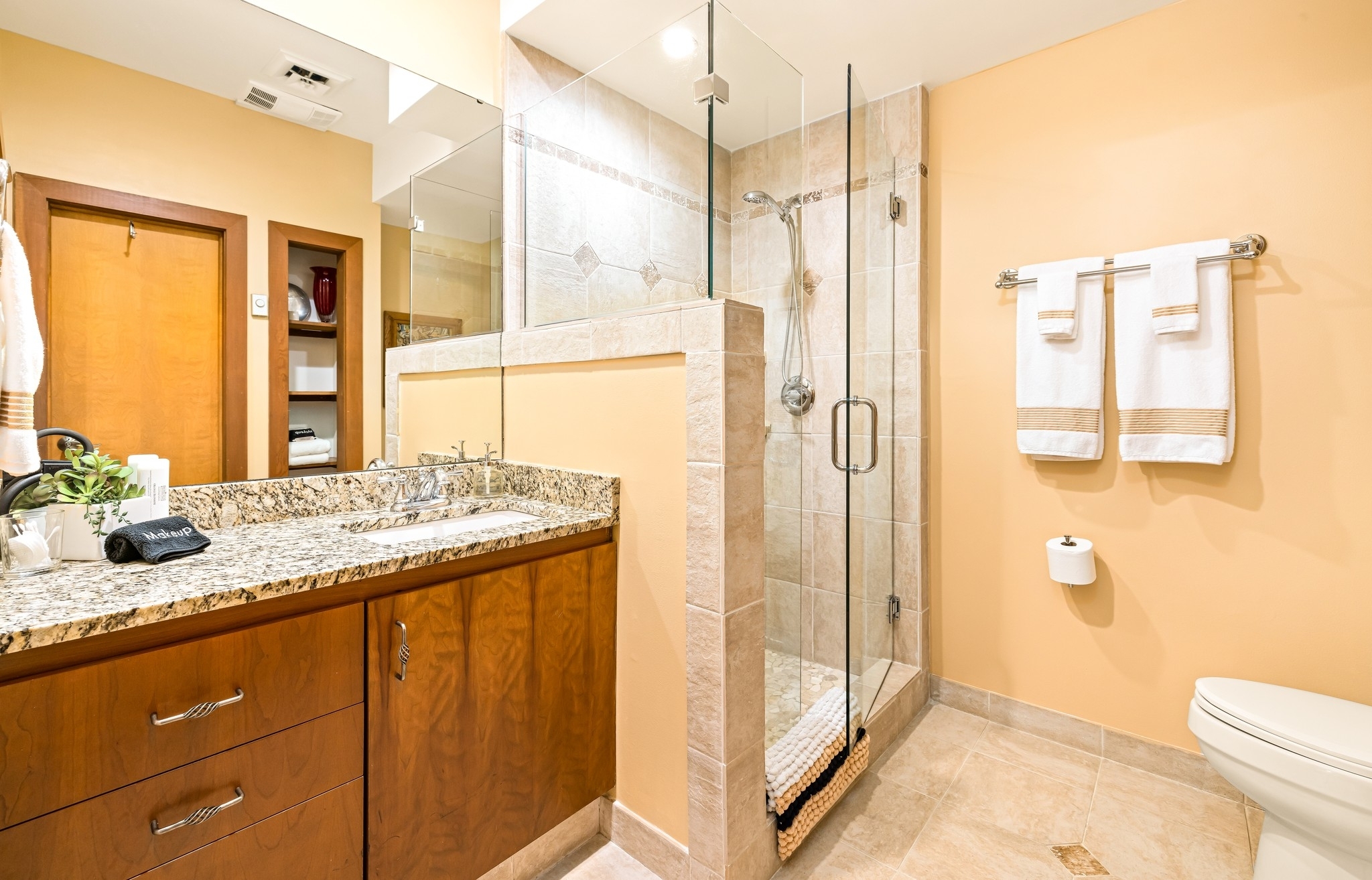 3/4 bath with glass walk-in shower features artisan bath soap, numerouos wash clothes and towels for your stay.