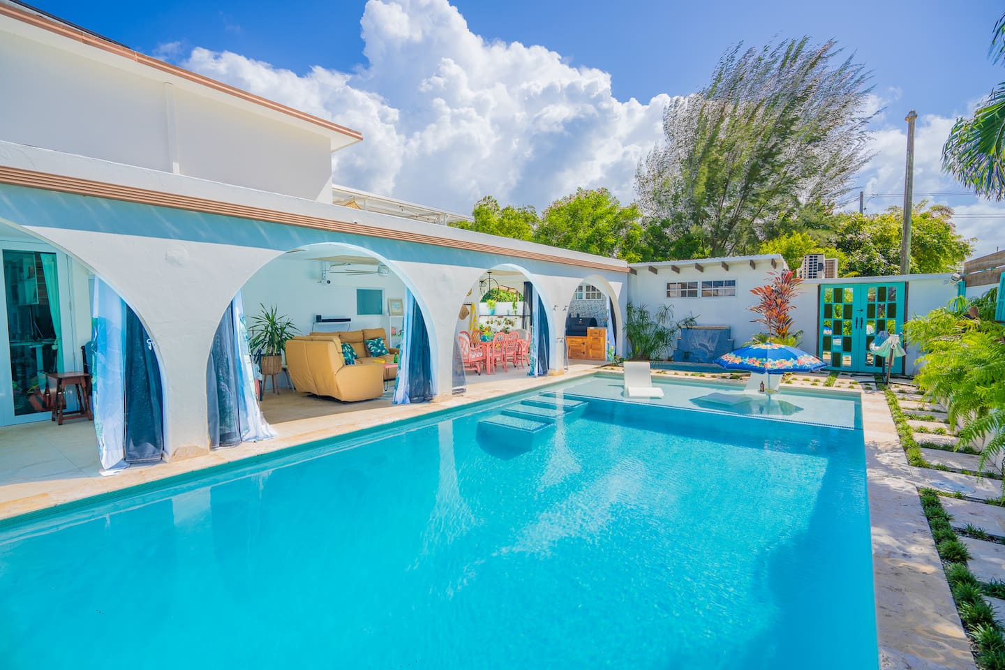 Here is the view from the deep end of the pool looking back towards the hot tub, al fresco dinning, seating area, and outdoor kitchen.