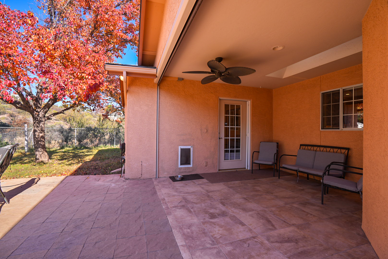 Covered patio with seating and direct backyard access—perfect for relaxing and great for traveling with pets