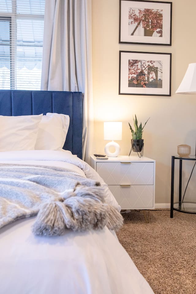 Cozy, spacious room with a queen-sized bed, TV, and a dedicated working space.