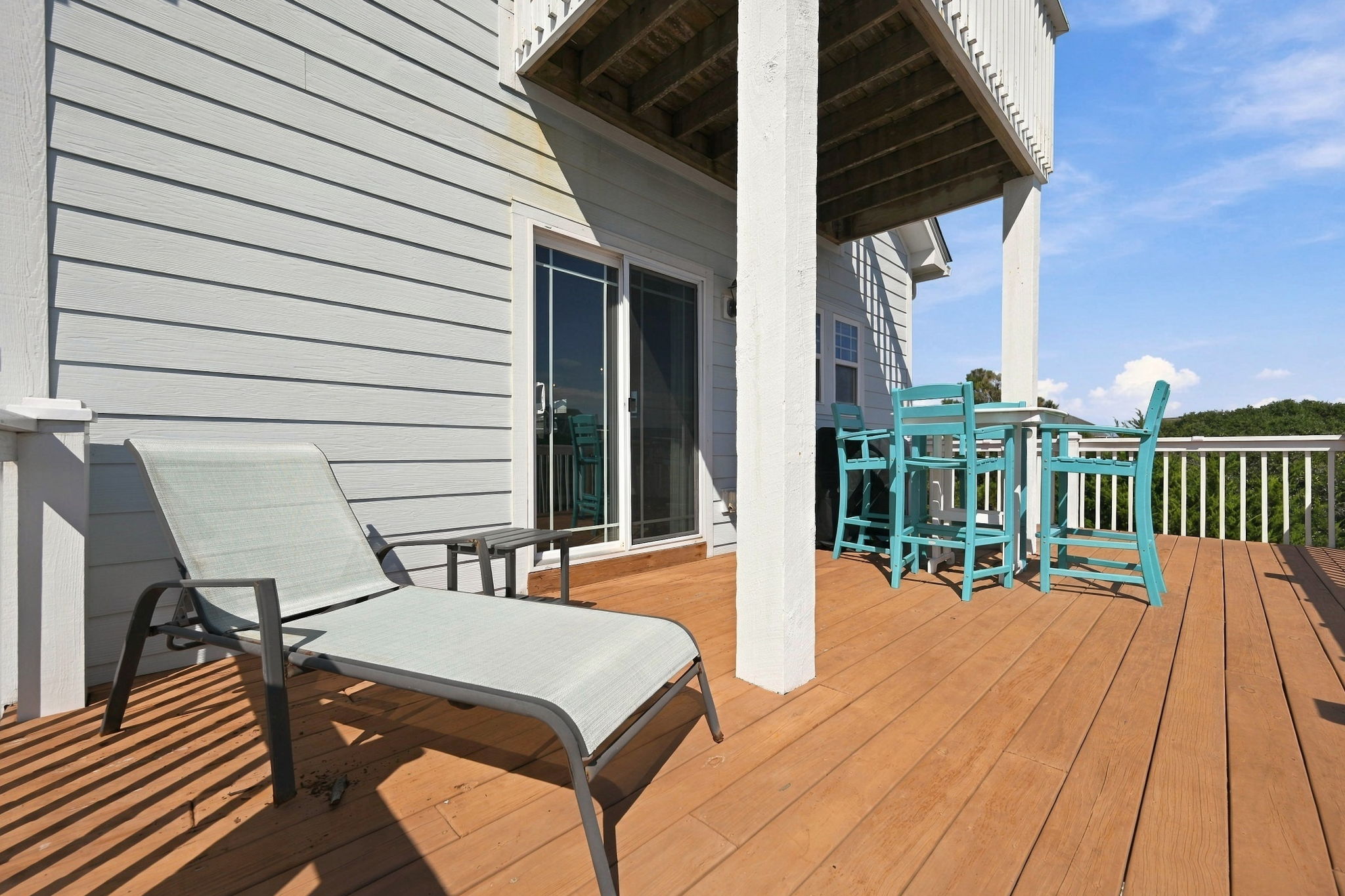 Soak up the sunshine on the spacious outdoor deck featuring lounge chairs, dining space, and refreshing coastal breezes
