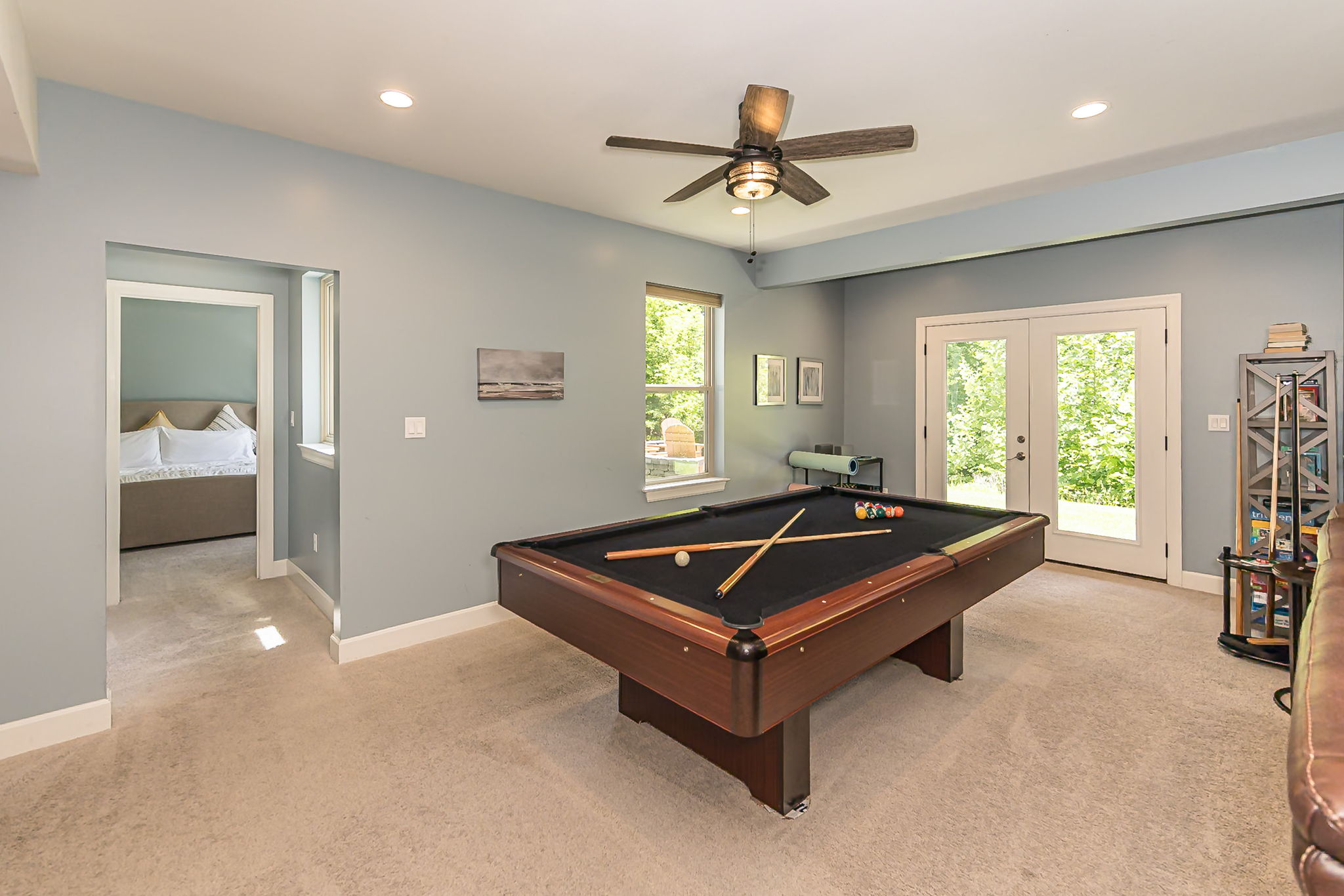 Pool table overlooks the wooded backyard.