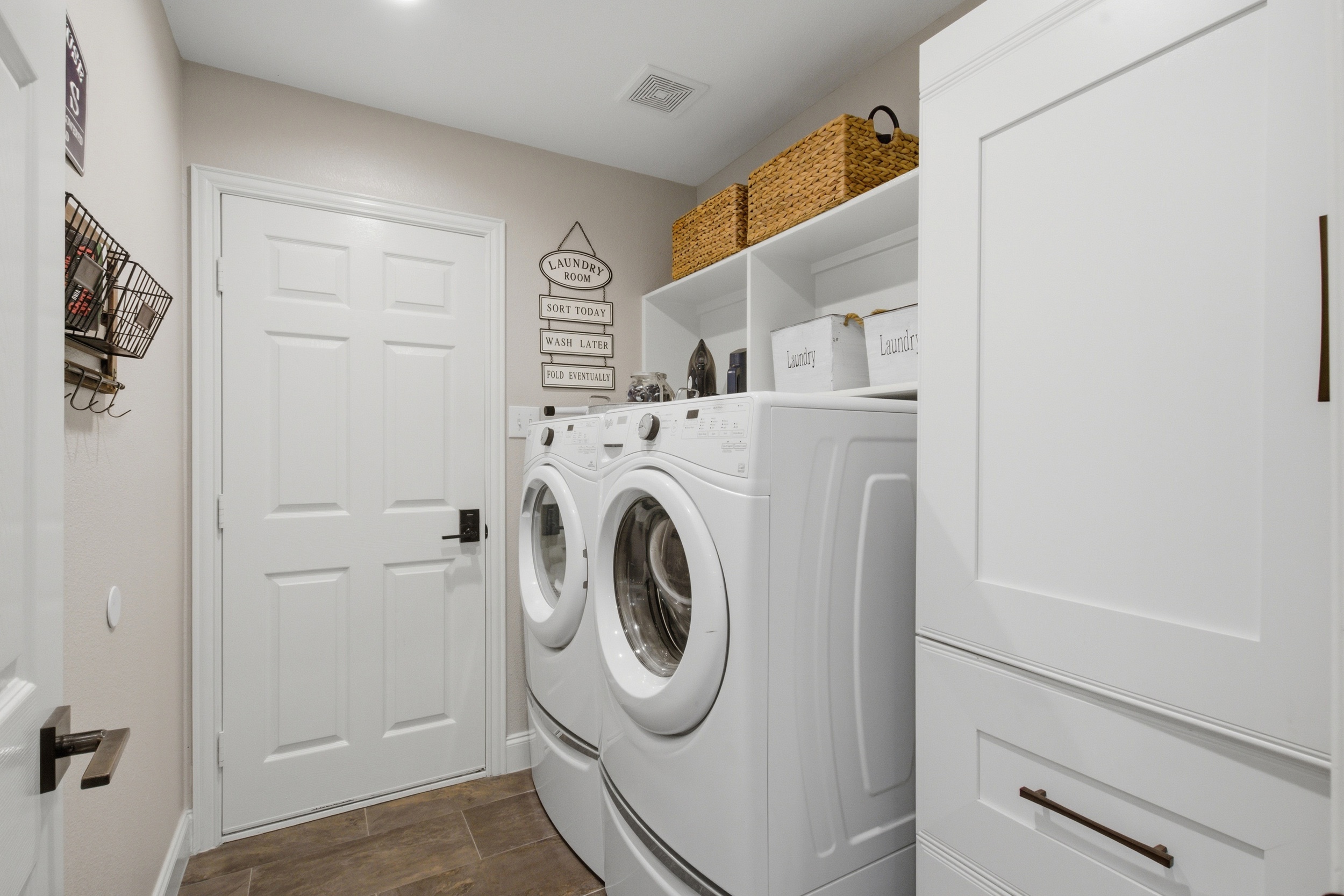 Dedicated Laundry Room with a Whirlpool Washer and Dryer, extra storage shelving, and clean modern fixtures. Pack light and do laundry on-site.

