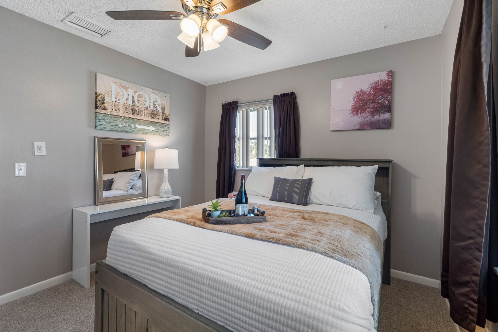 Neutral walls, crisp white bedding, and subtle accents provide timeless style and comfort.