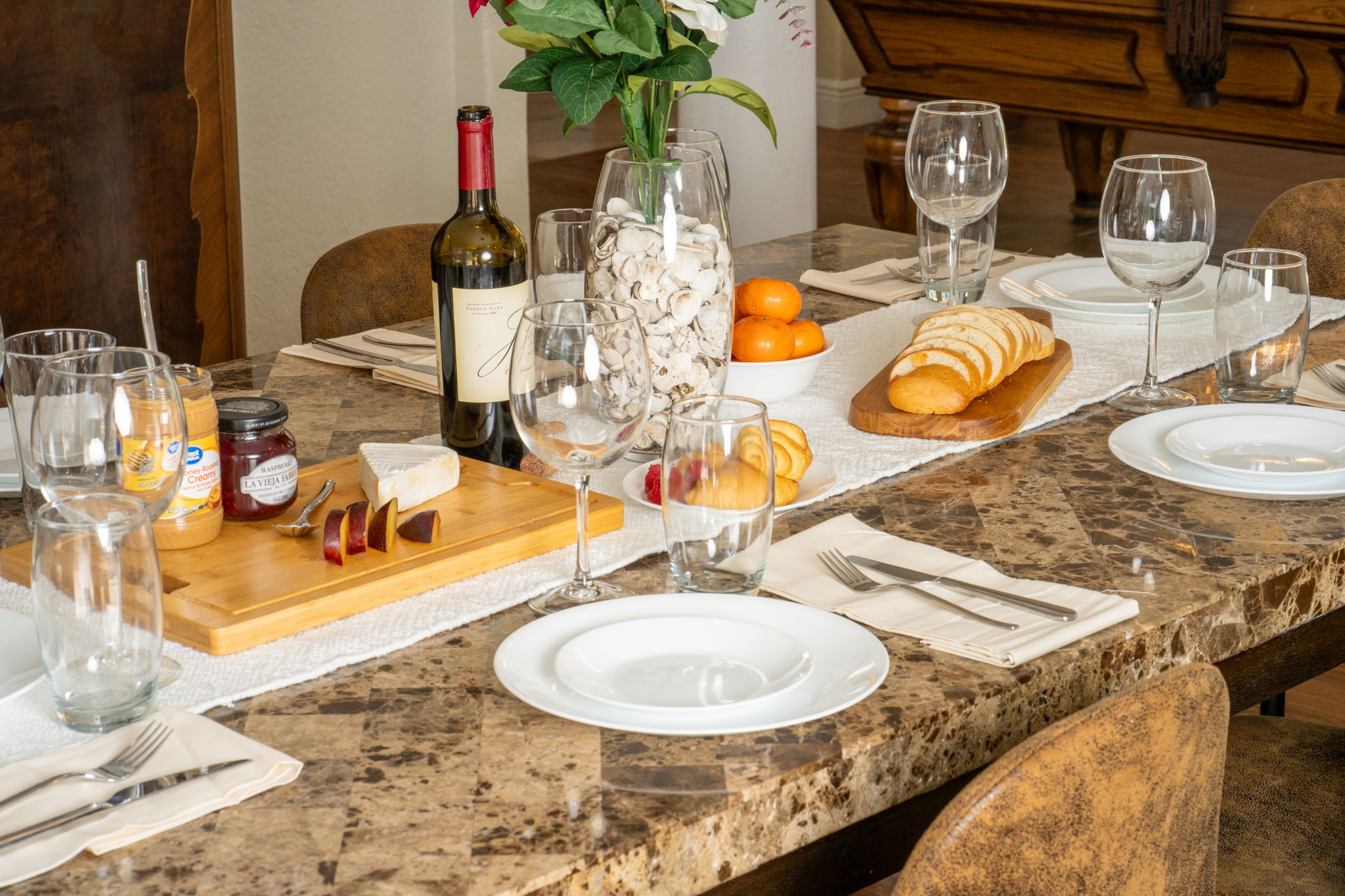 This sophisticated dining space features crown molding, rich wood floors, and classic architectural columns for a timeless appeal.