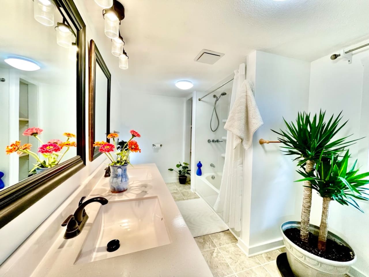 Tile floor bathroom with double sinks and tub. Two person infrared sauna (to ther right and not pictured).