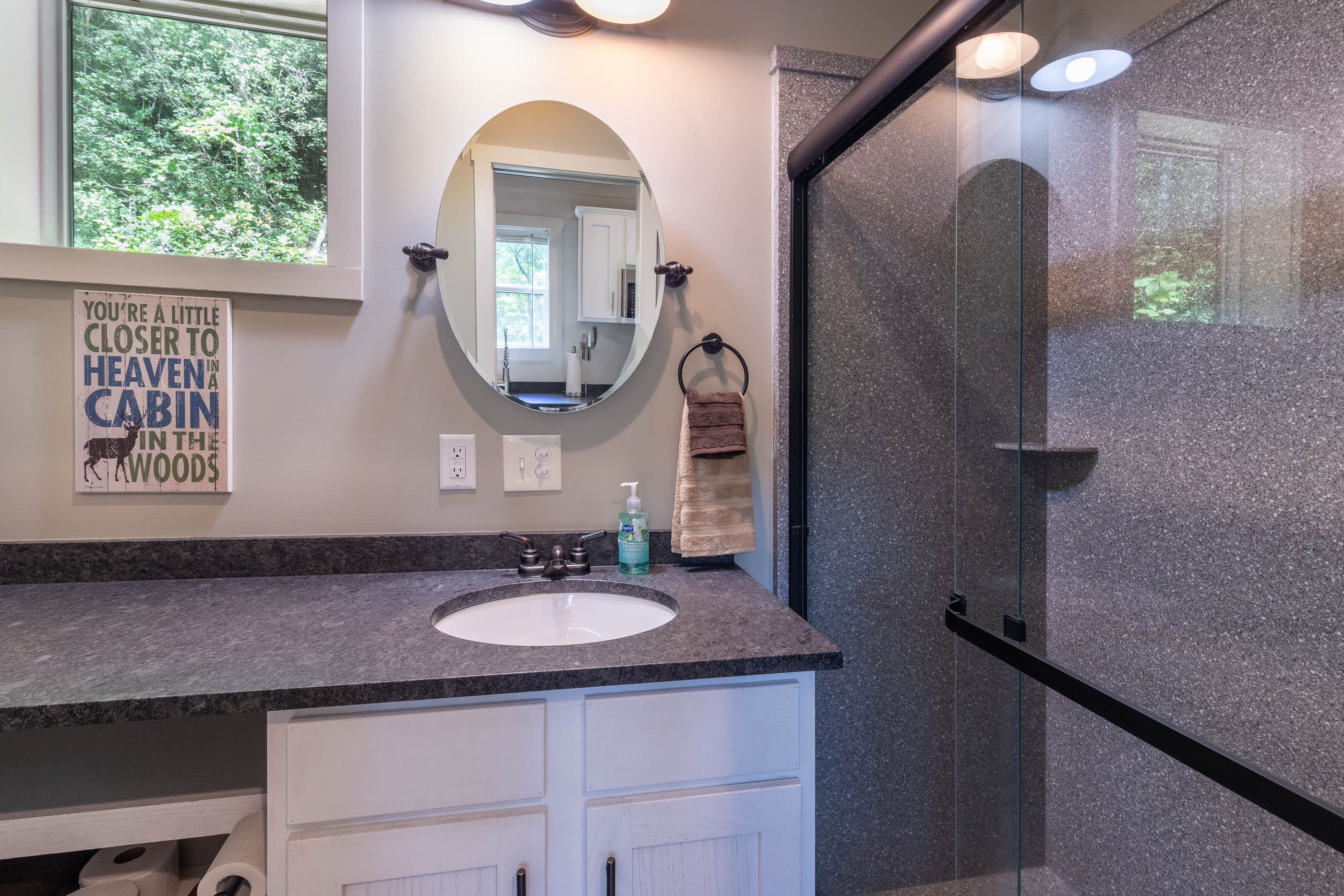 Refresh in the modern bathroom featuring a glass walk-in shower and plenty of counter space.