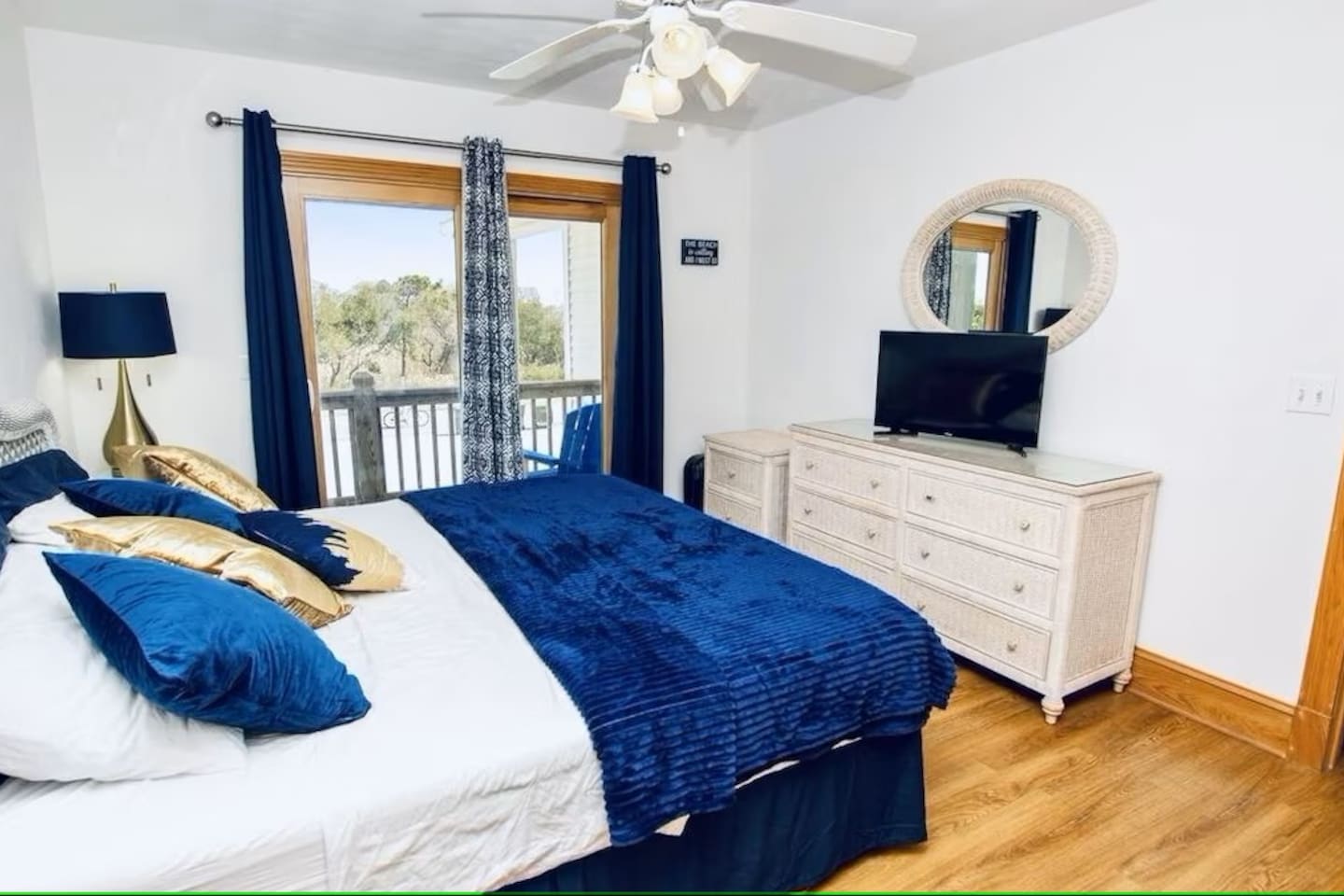 Serene bedroom offering deck access through a windowed entrance, and equipped with a TV.