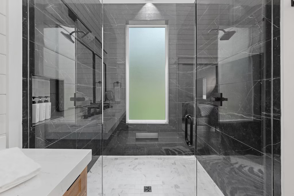 Spa-Like Retreat: Indulge in a sleek, modern shower with stunning tile work and natural light!