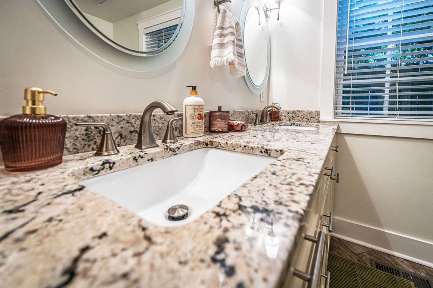 Elegant bathroom with a large mirror, stylish faucet, and a selection of essential toiletries for your convenience.