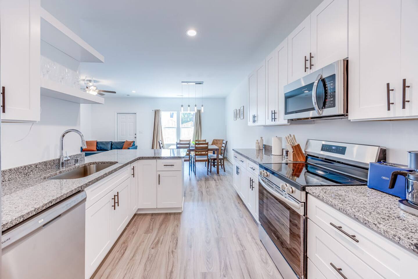 Experience a brand-new kitchen with stainless steel appliances that seamlessly opens to a spacious dining area, perfect for gathering and entertaining.