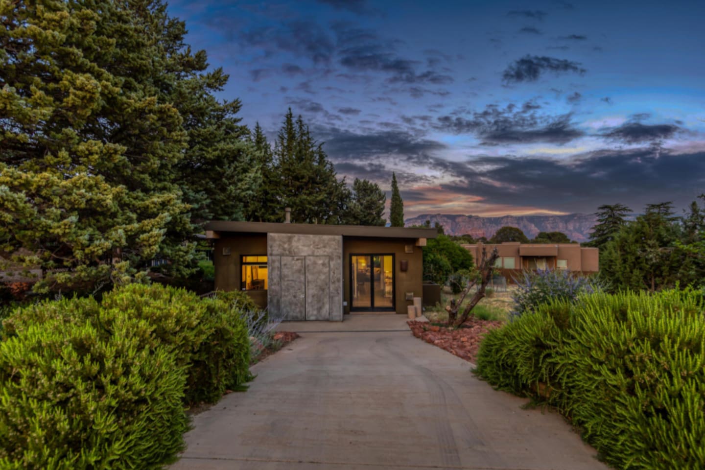 Charming private entrance at sunset, with a peaceful walkway framed by lush greenery and distant mountain views.