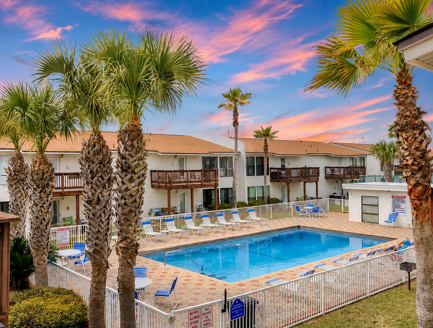 Poolside Paradise at Navarre Beach. Palm-lined pool deck just steps from your door, with loungers, patio seating, and a private grill area. The perfect spot to unwind between beach trips.