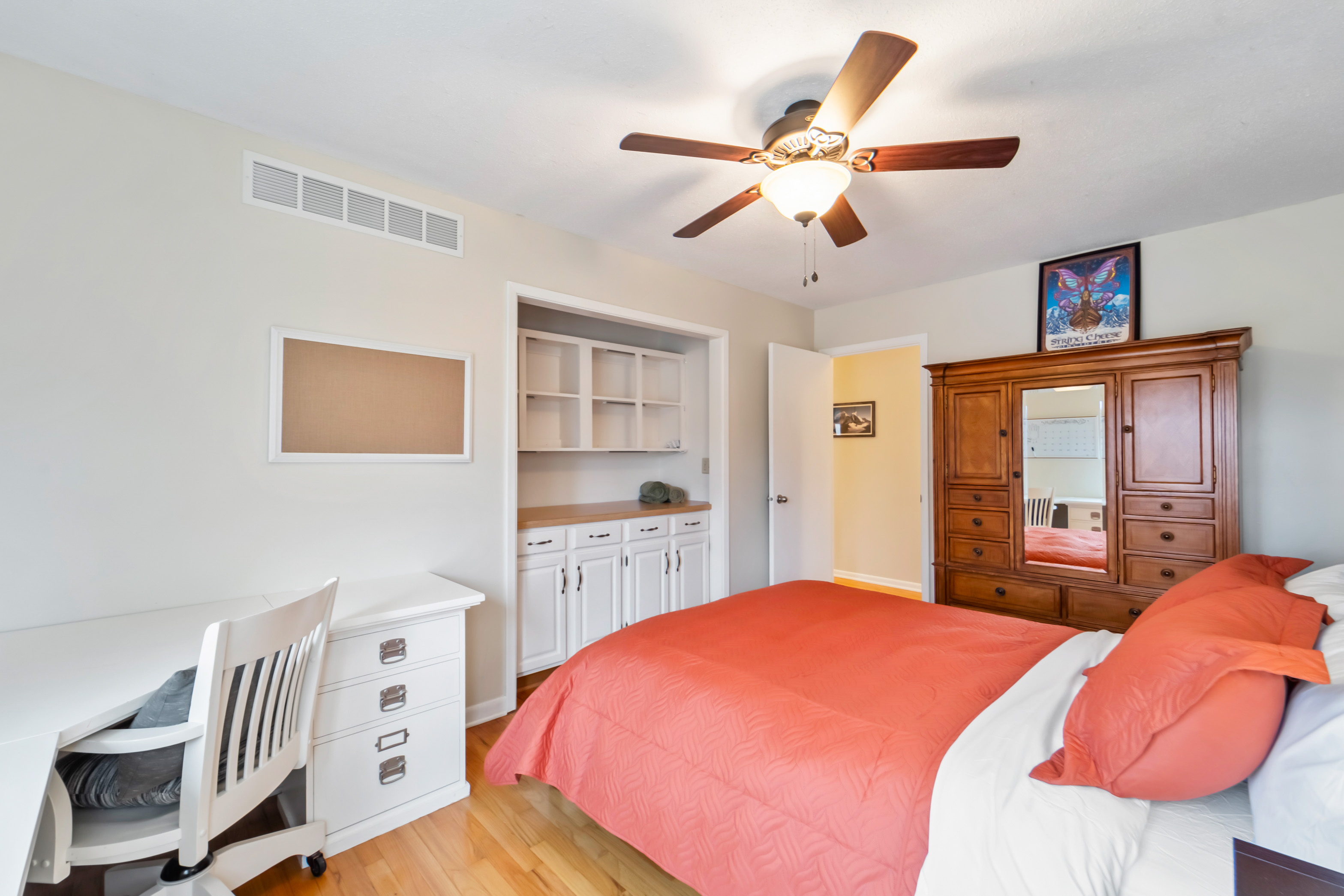 The first bedroom from the kitchen has a queen size bed and tons of clothes storage. The closet was turned into a desk and office storage for a more friendly work from home set-up.