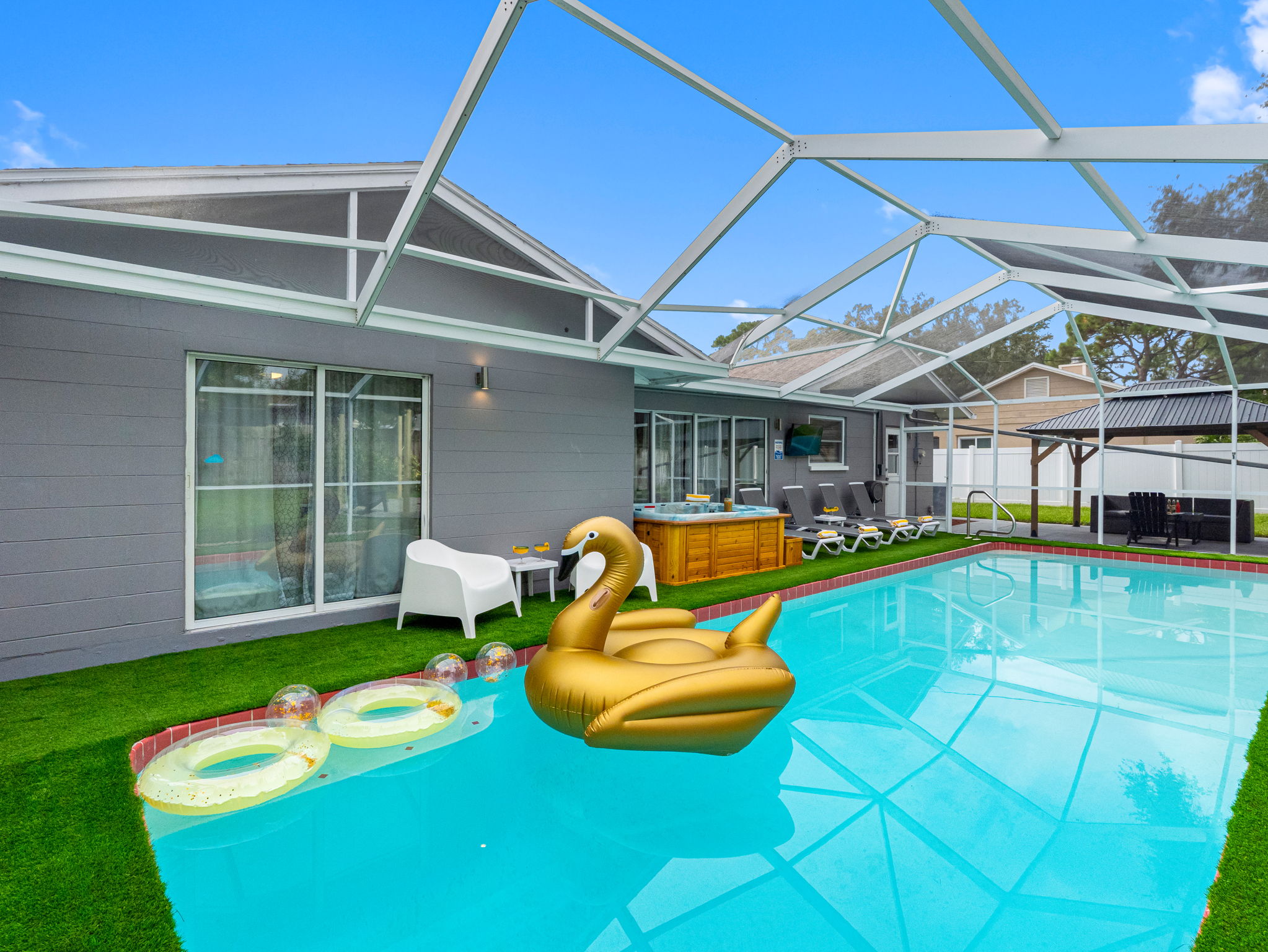 This vibrant pool area is the perfect spot for family fun or quiet relaxation, complete with floaties and streaming-ready TV.