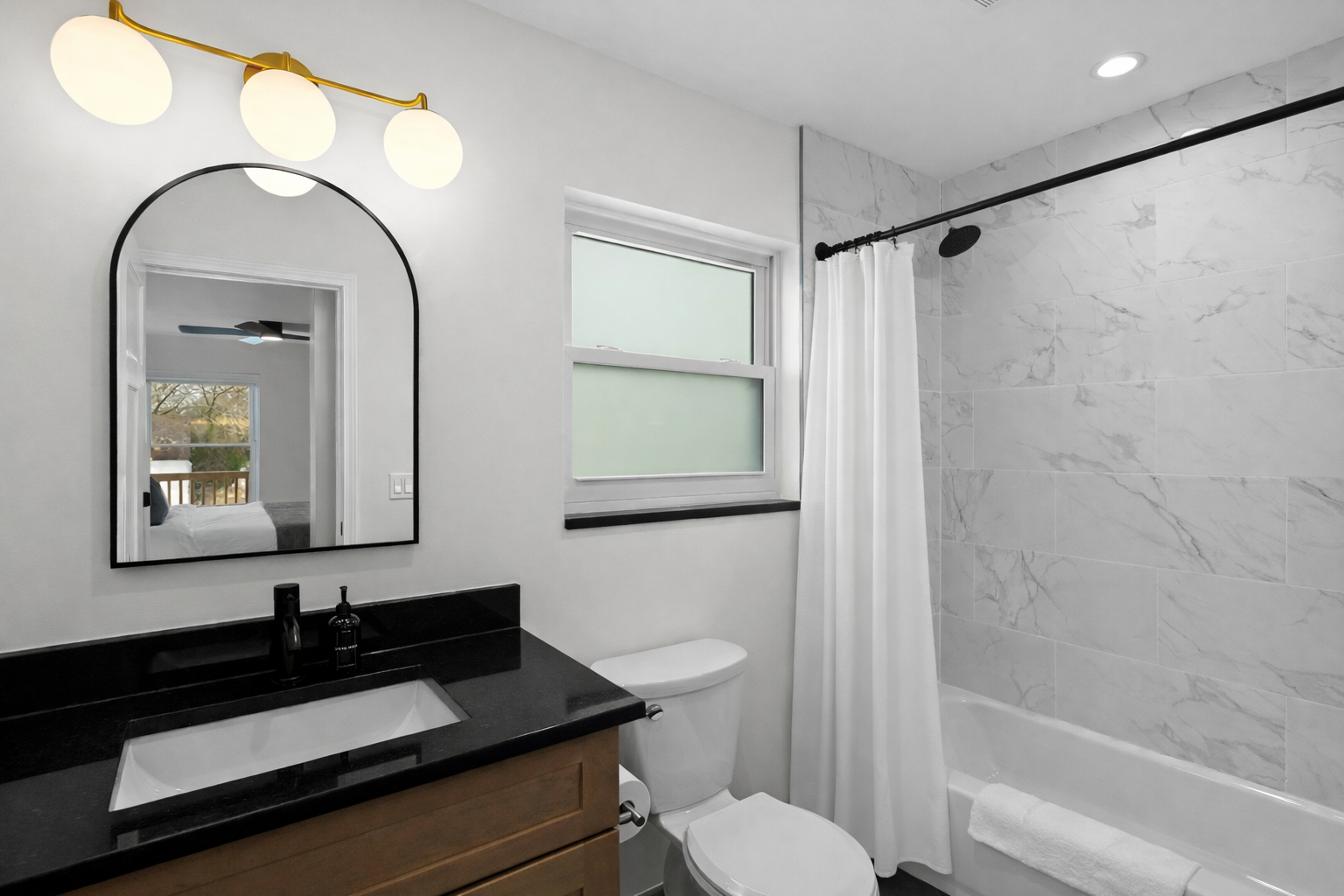 Clean, modern bathroom with sleek vanity, bright lighting, and a tiled shower—designed for comfort, convenience, and a refreshing start to your day.