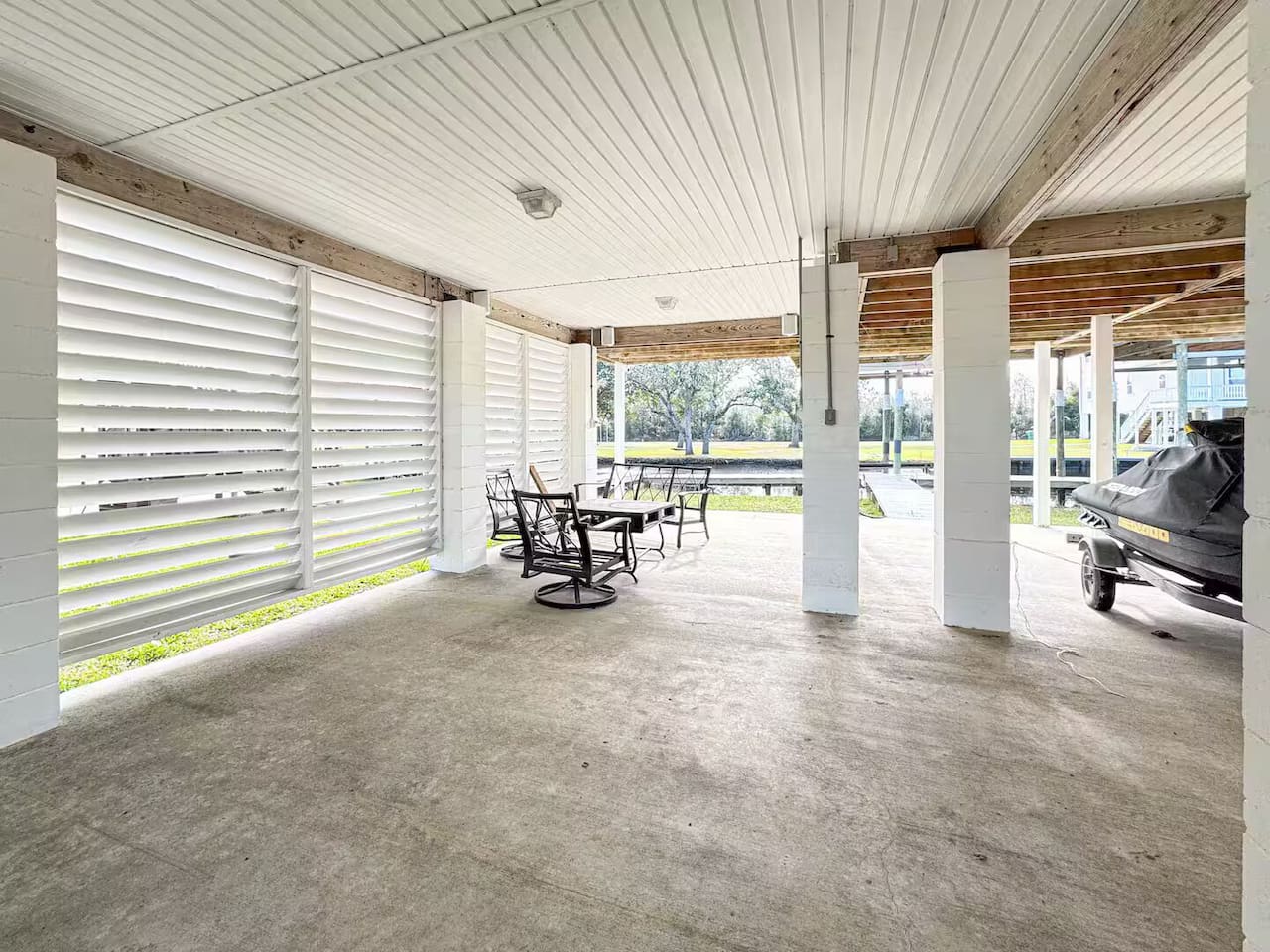 Large shaded patio beneath the home featuring seating space and plenty of room for outdoor hangouts.