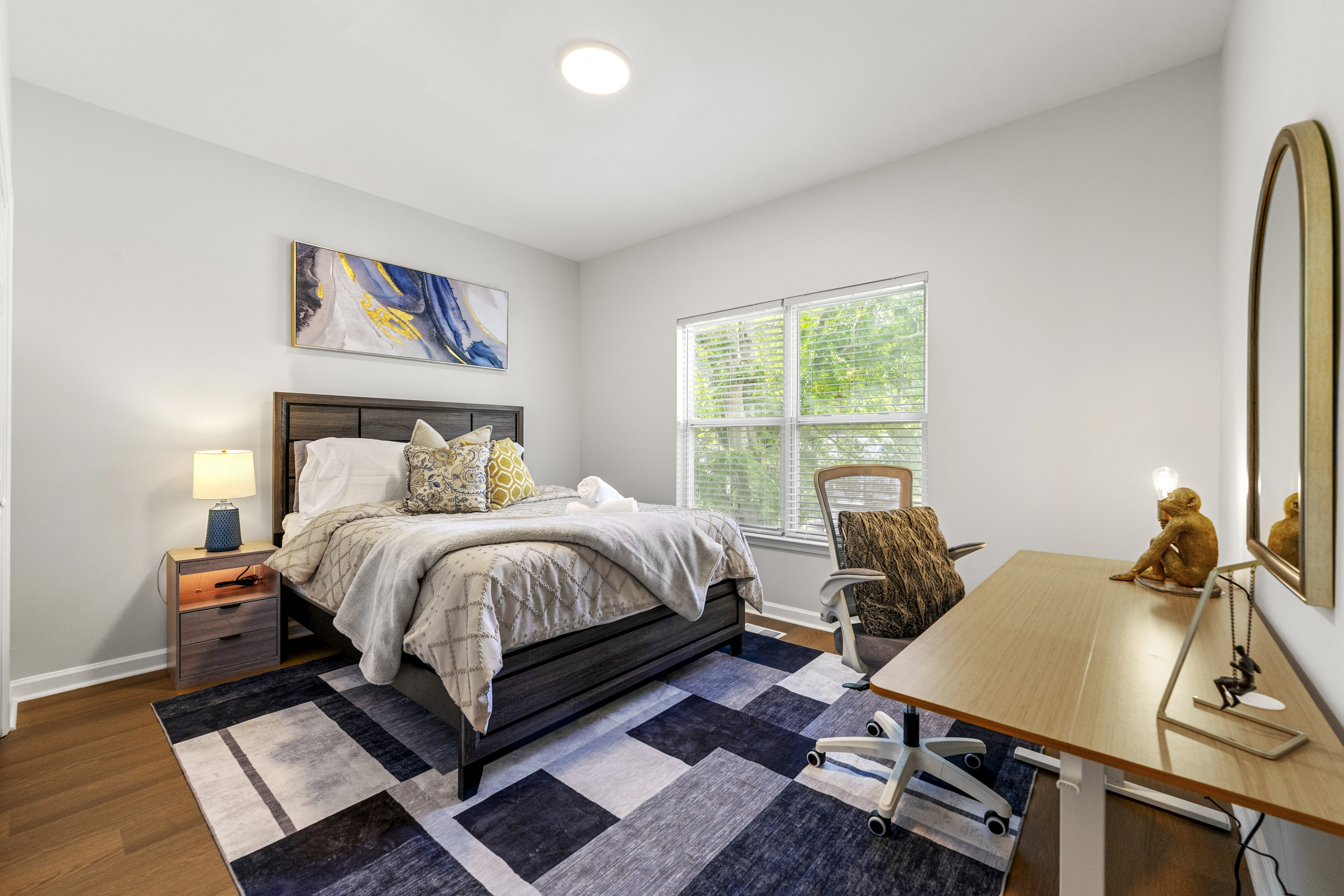 Rest easy in this serene queen bedroom with soft bedding and calming decor.