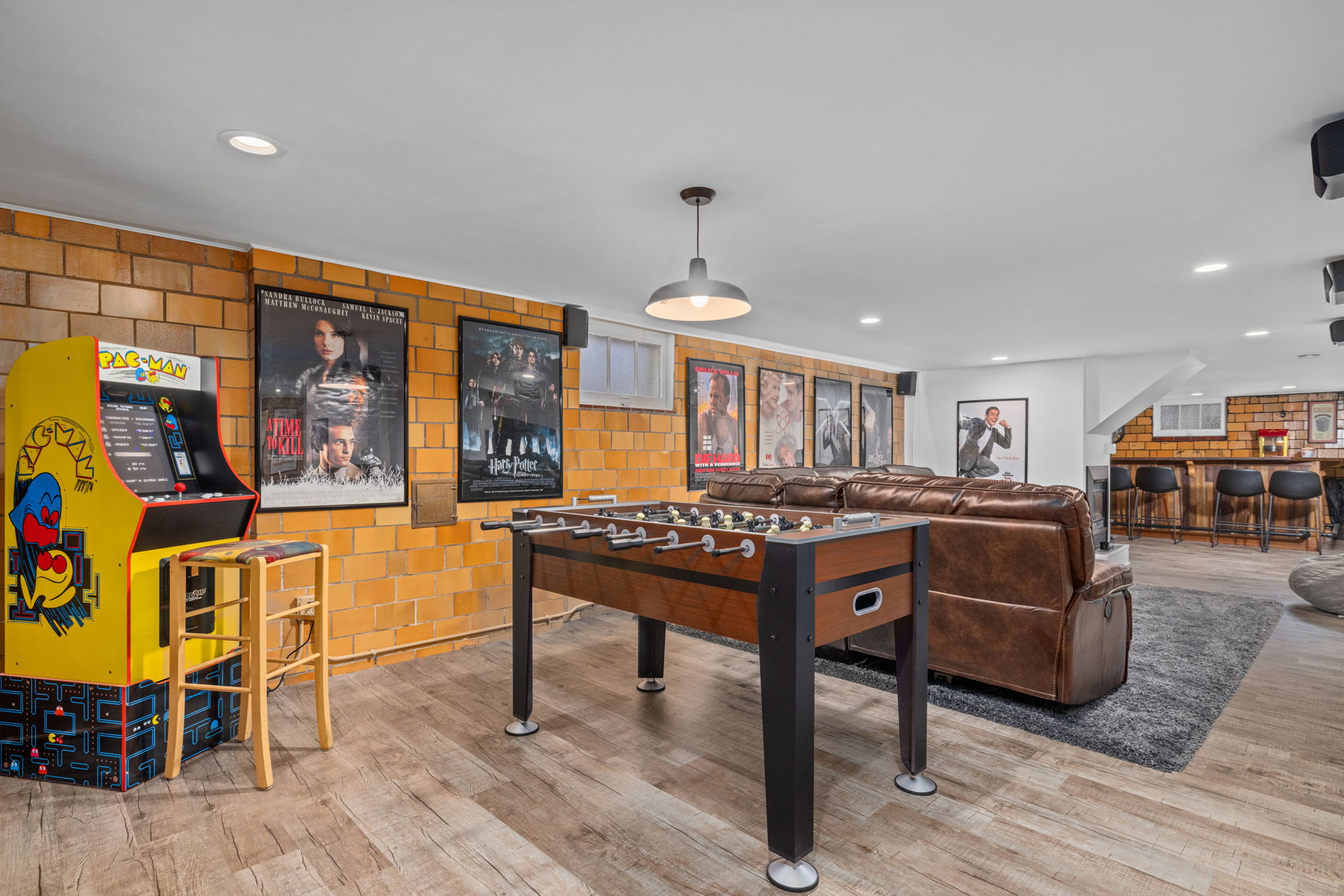 Lower level entertainment room with artificial fireplace, large sectional with 3 power recliners,   75" flatscreen smart TV with surround sound, dry bar, foosball table, air hockey/pool table,