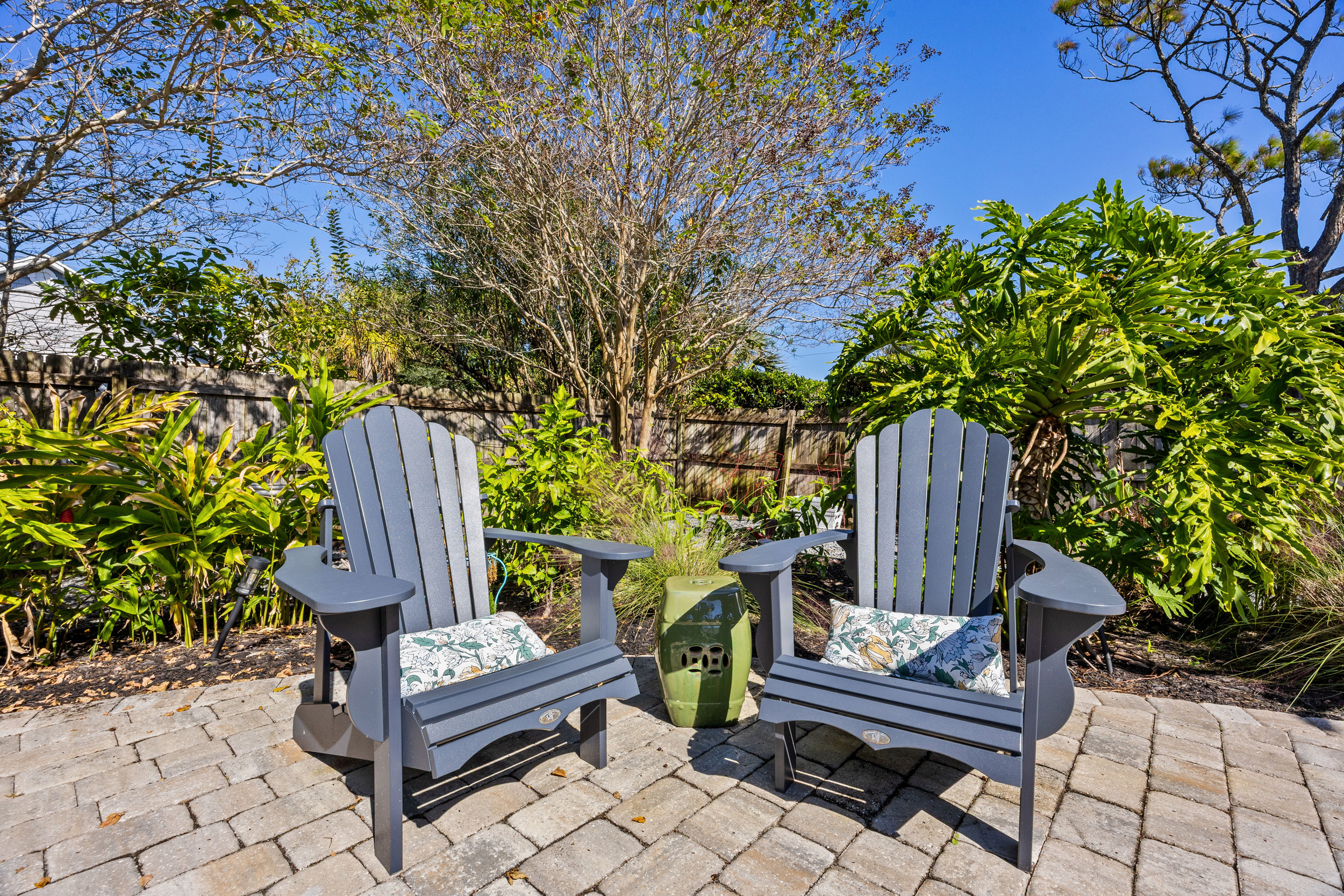 Peaceful Adirondack Garden Corner
Two Adirondack chairs with decorative cushions sit among tropical plants, creating a shaded, tranquil retreat. A perfect spot to enjoy a drink or unwind outdoors.