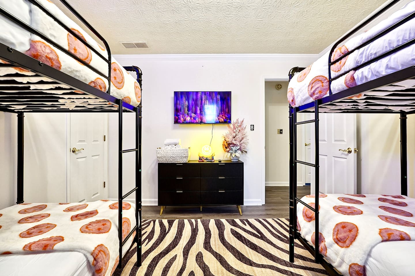 Bedroom 5 is located upstairs, features double bunk beds and a TV. This room does not have a private en-suite bathroom but has access to a shared bathroom.