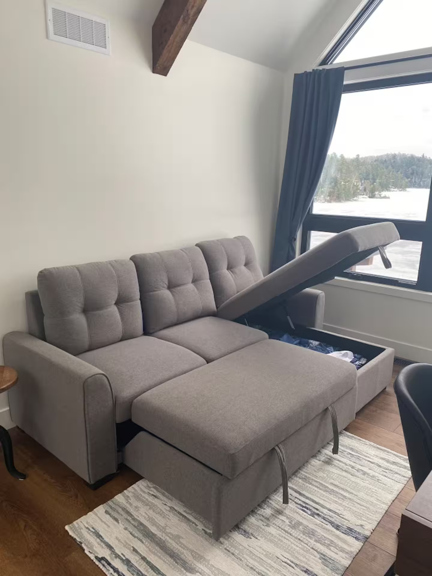 Sleeper sofa storage showing where to find bedding and linens when needed.