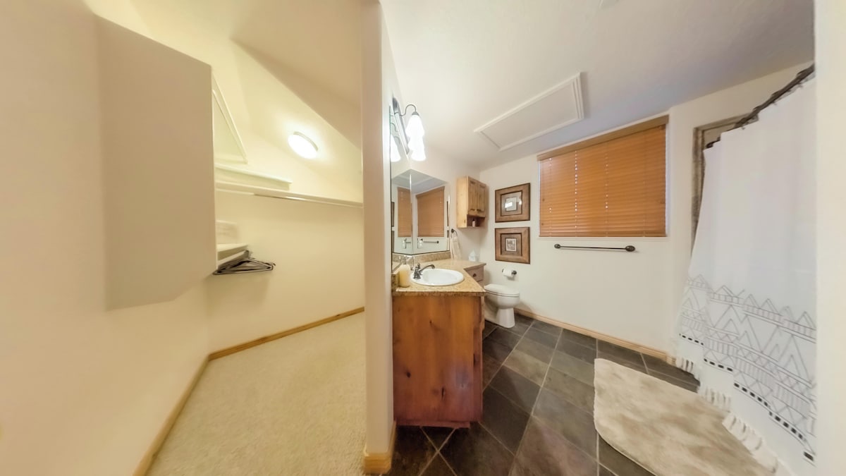 The primary bathroom features plenty of counterspace, ample storage, a hair dryer, and expansive mirrors.