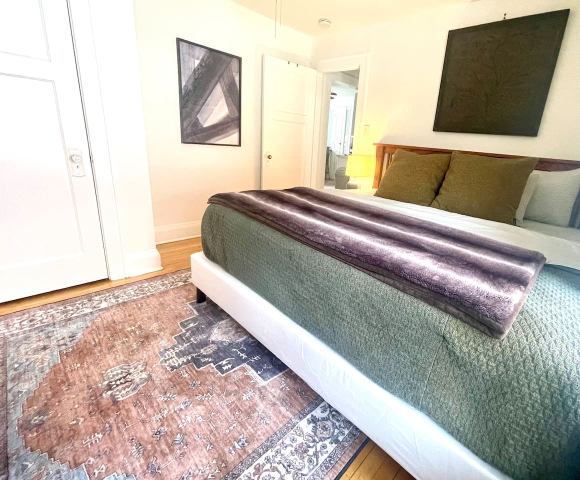 King bedroom with plush bedding, layered textures, and warm lighting—an inviting retreat for deep, restful sleep.