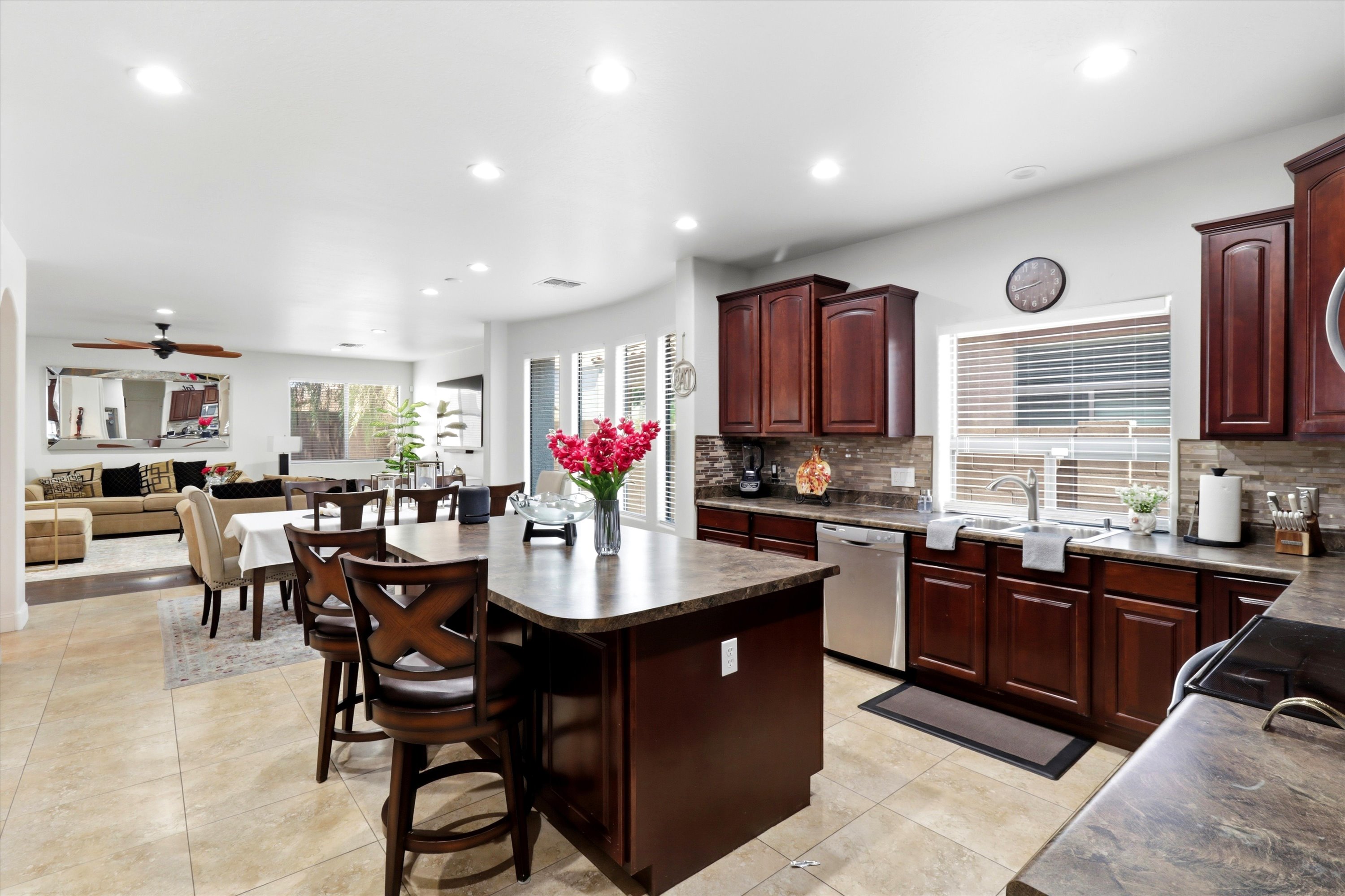 Kitchen with island seating, full appliances, and an open view into the dining and living areas.
