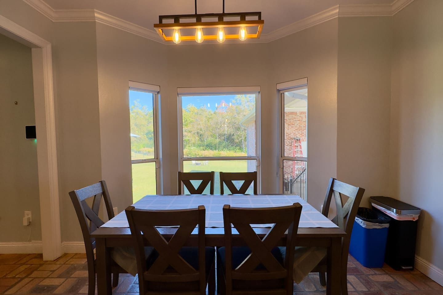 A rectangular wooden table with a crisp white tablecloth sets the stage for shared meals.