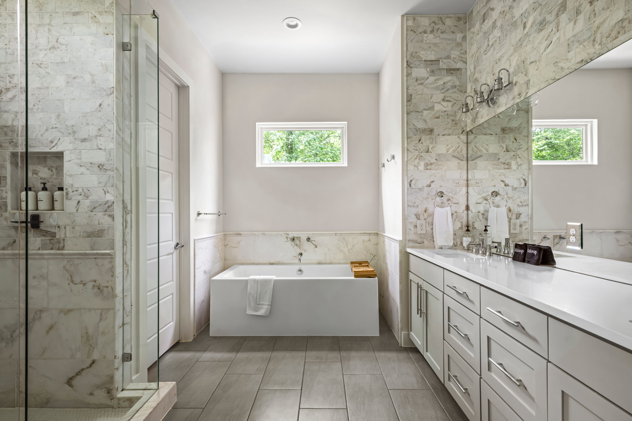 Spa-inspired bathroom with a deep soaking tub, marble surround, and natural light pouring in — the ultimate space to unwind.