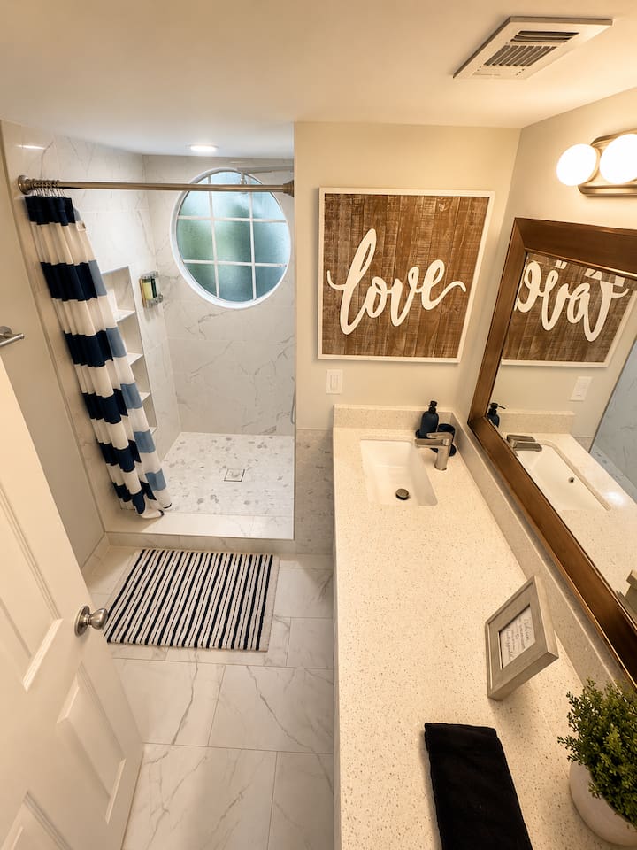 Bright bathroom with a walk-in shower, spacious vanity, and modern finishes.