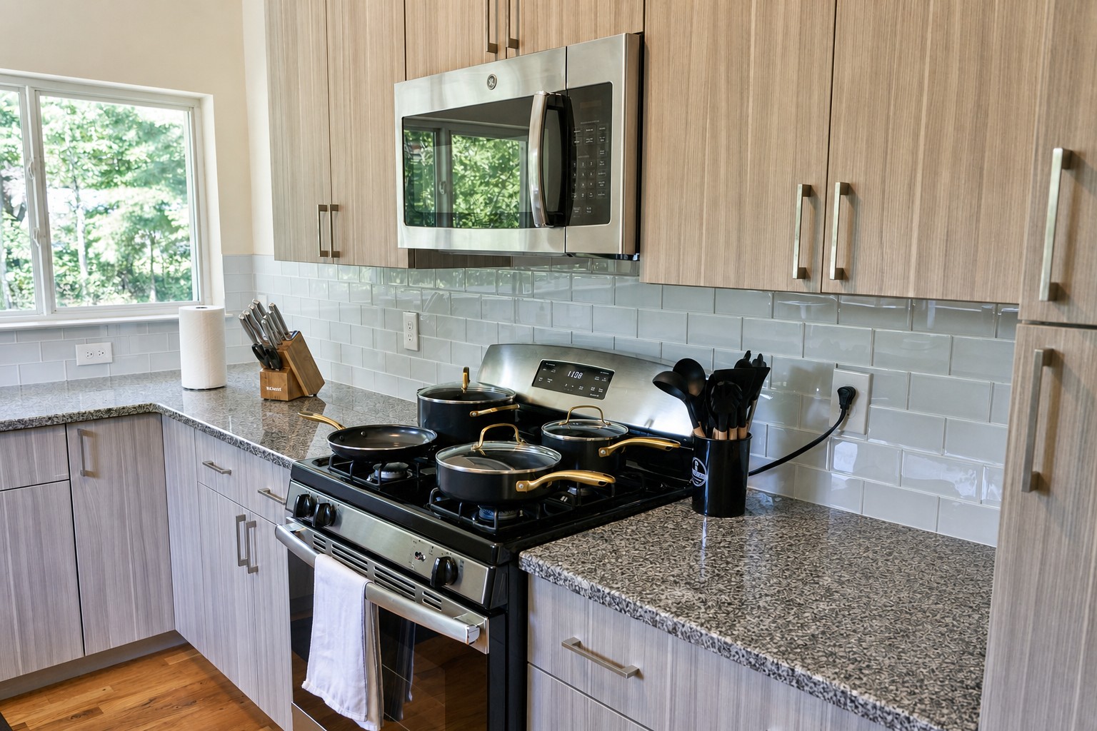 Kitchen with microwave, cookware and a window over the woods