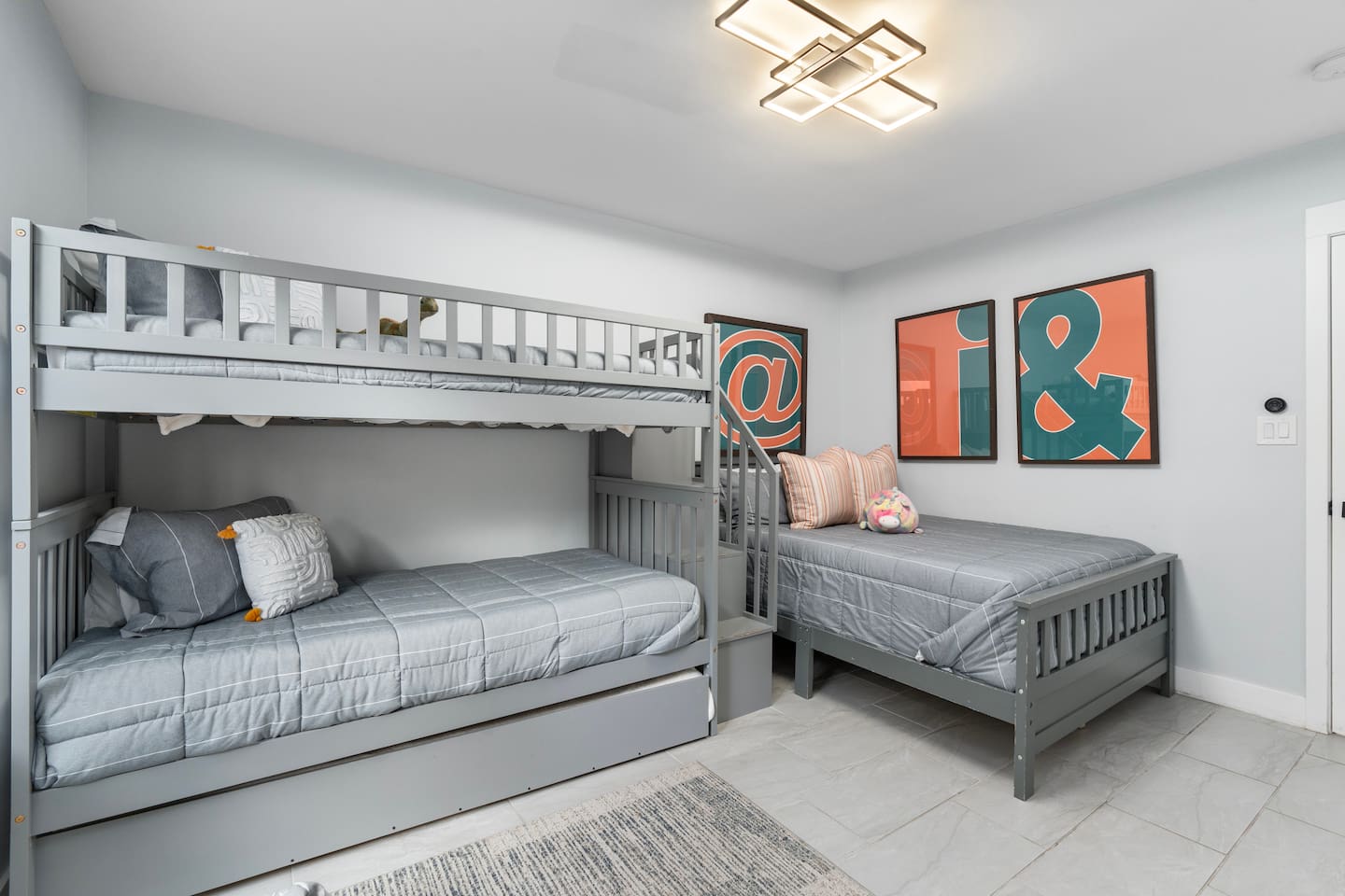 Spacious setup with bunk and trundle combo plus a cozy single bed.

