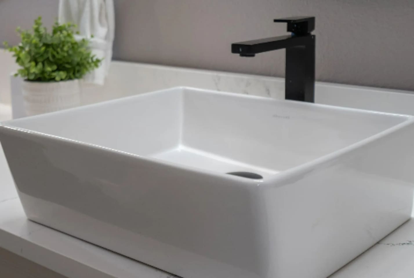 A sleek vessel sink and matte black fixtures add a modern touch to the bathroom details.