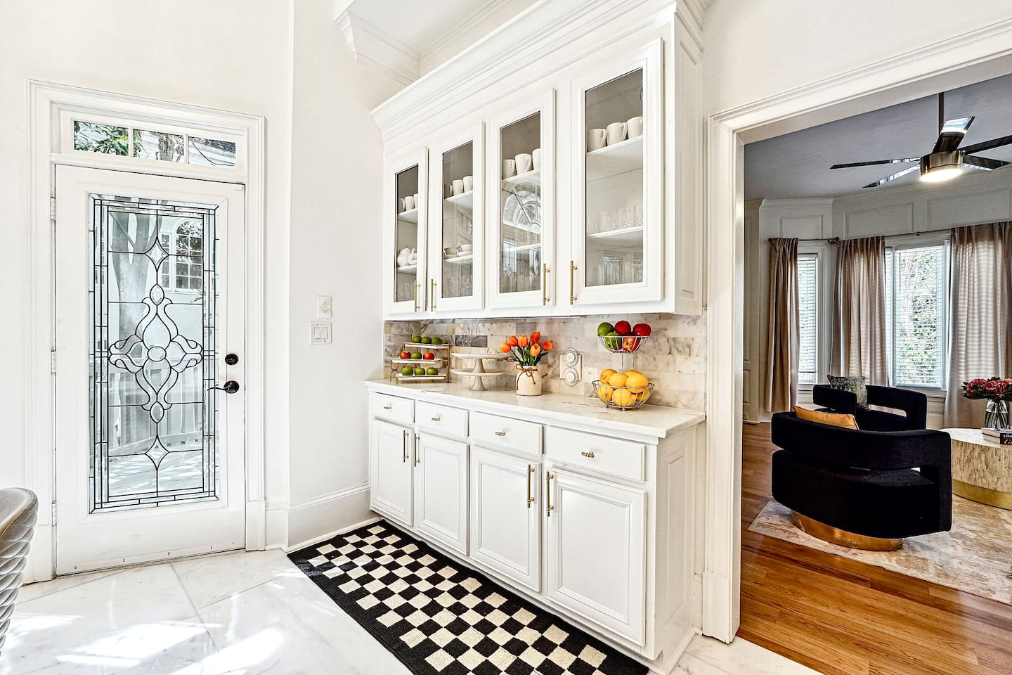 Bright and beautifully designed kitchen with white marble counters and white wood cabinetry. Fully equipped and ideal for cooking, gathering, and hosting with ease.