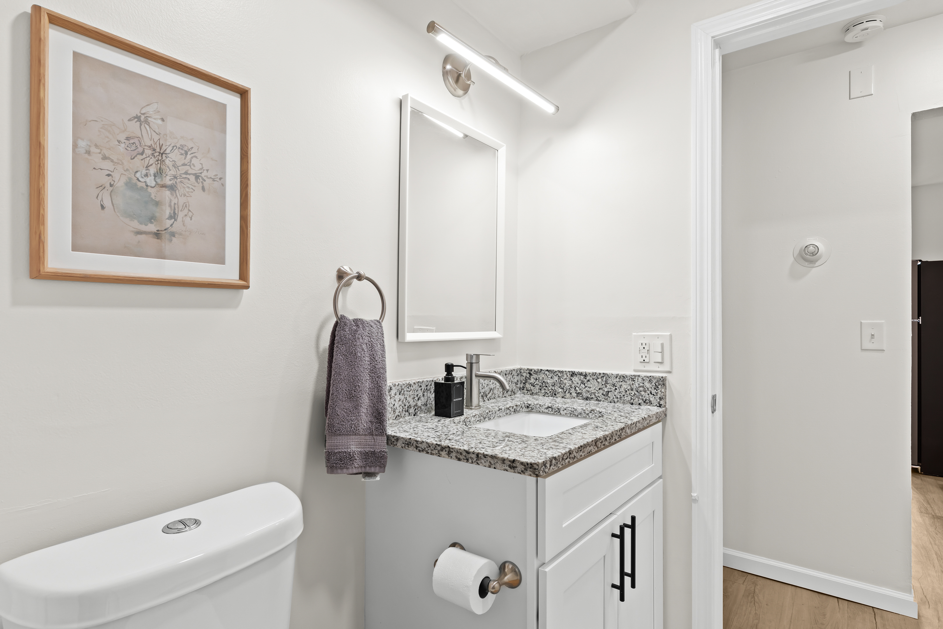 Fresh and modern bathroom with granite countertop and calming décor touches.