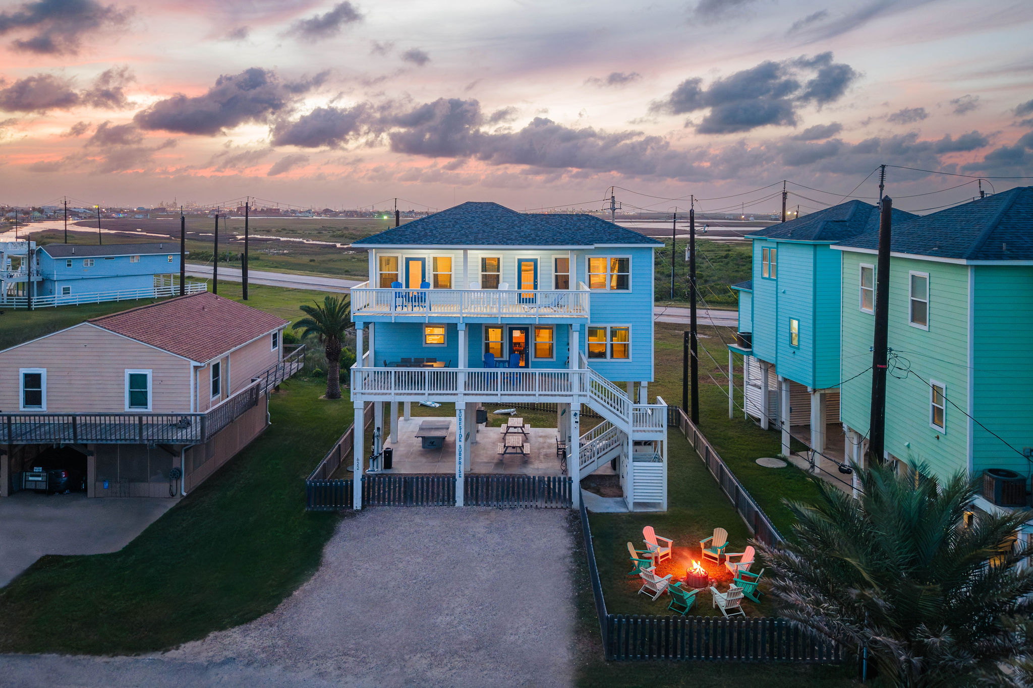 Golden-hour welcome — firepit already lit, deck seating for the crew, Gulf just 3 minutes away. Your beach week starts here