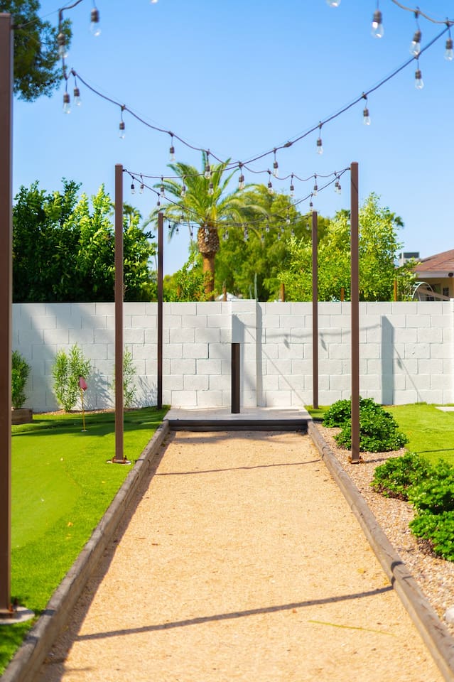 Stroll along the scenic outdoor walkway by the mini golf course, perfect for a cozy backyard event or intimate wedding. A beautiful setting for special moments!