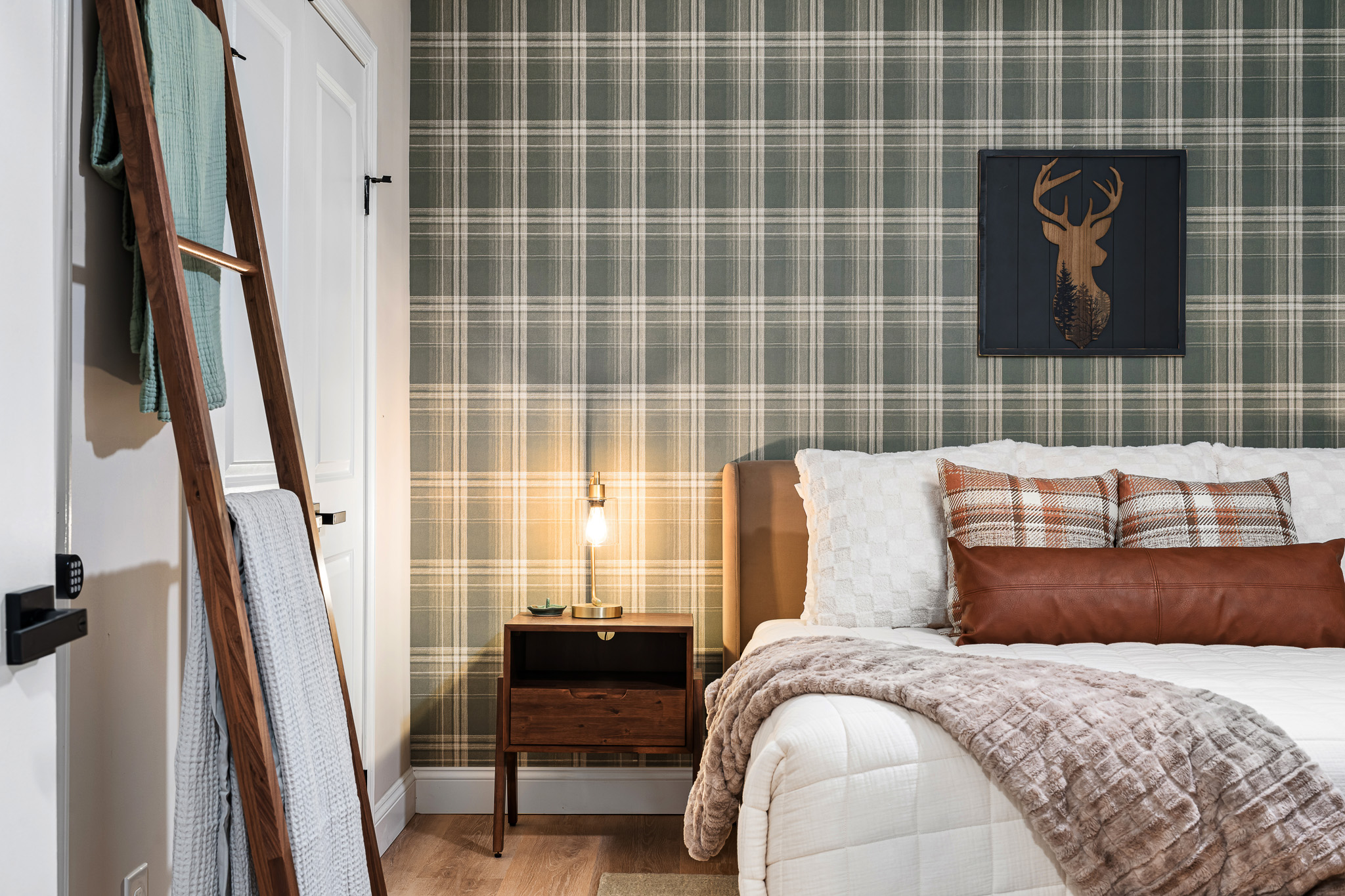 An up-close look at the plaid-accented bedroom, highlighting the mix of textures and colors—perfect for a mountain getaway with a touch of luxury.
