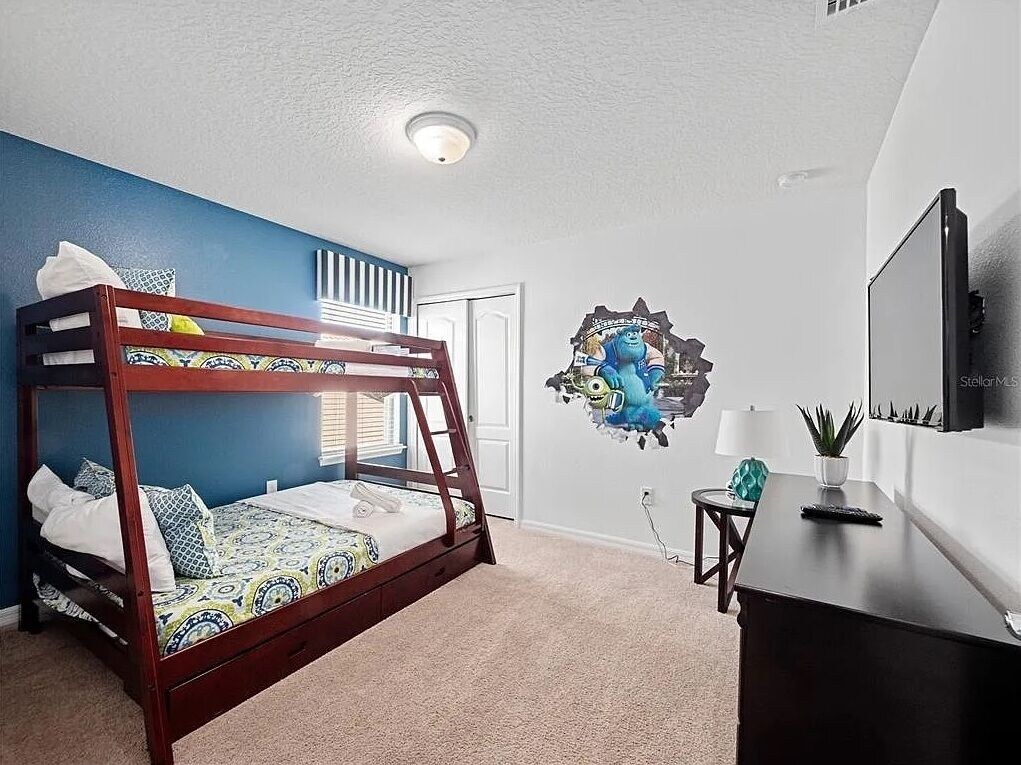 Monsters Inc. themed bedroom with full bed under and twin above