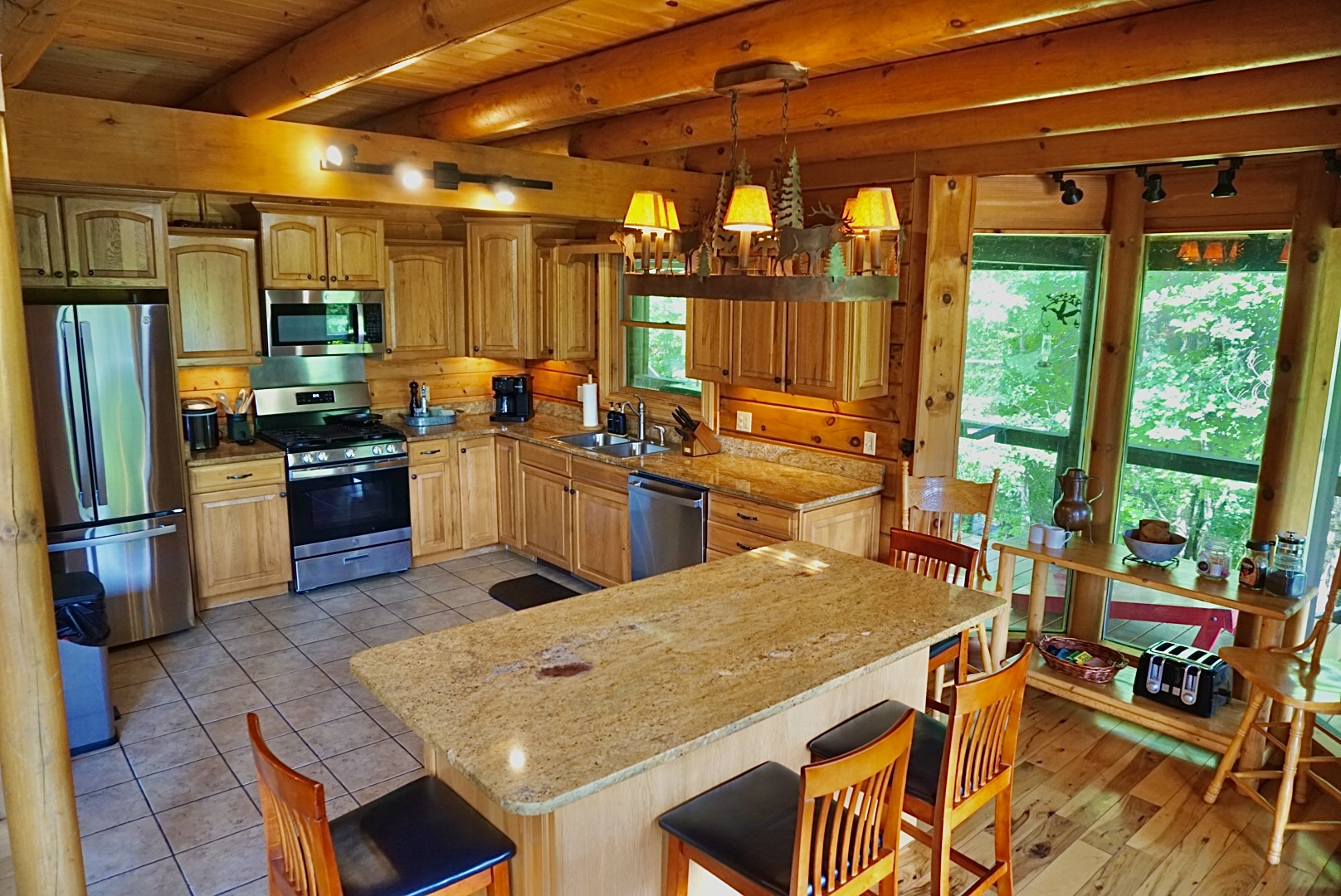 Gourmet Kitchen Retreat: Spacious granite counter, luxury appliances, and nature-inspired lighting await!
