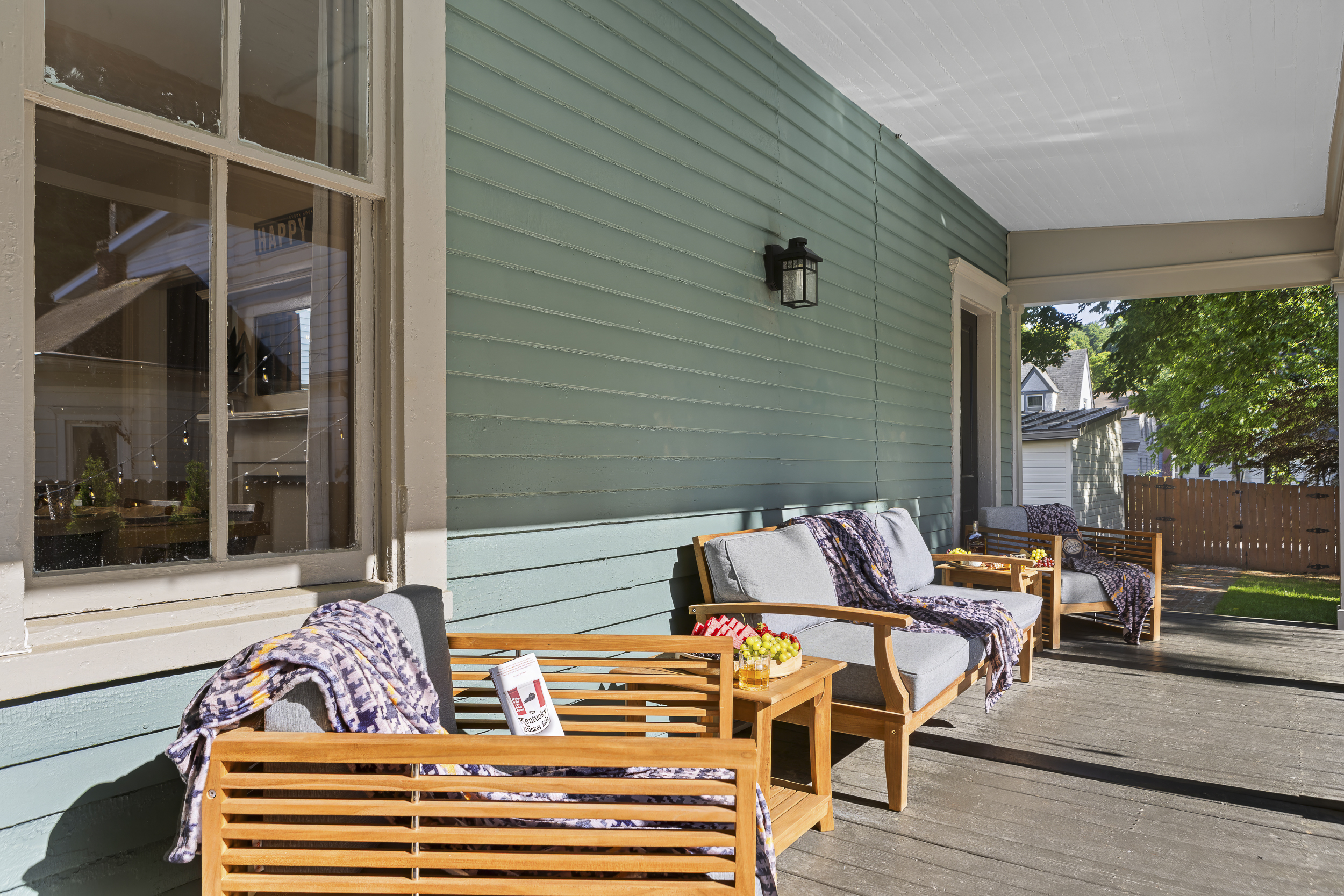 Relax on the covered back porch in teak loungers, the perfect spot for a morning coffee or a leisurely evening pour.