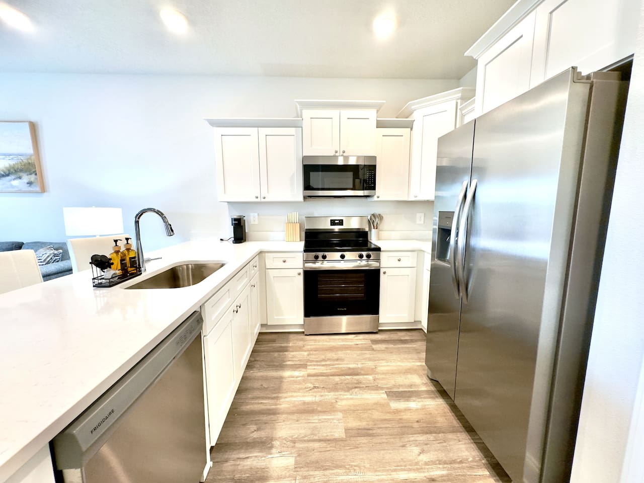 Cool countertops under your palm, the quiet hum of stainless steel appliances. Warm light overhead, wood floors underfoot. Everything crisp and clean, ready to cook, easy to move around in.