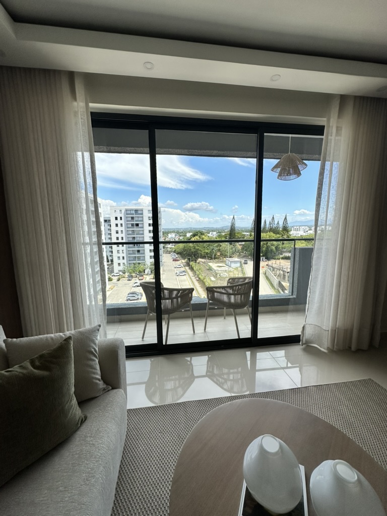 Floor-to-ceiling glass doors frame beautiful views of Santiago and the mountains beyond. 🇩🇴⛰️