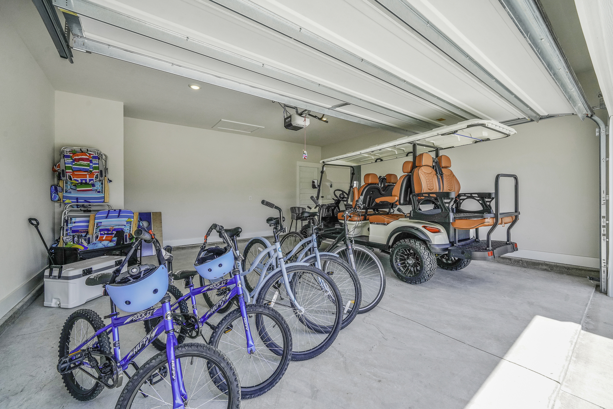 Enjoy a large garage featuring beach essentials and a brand-new 6-seater golf cart to explore the town and nearby beach.