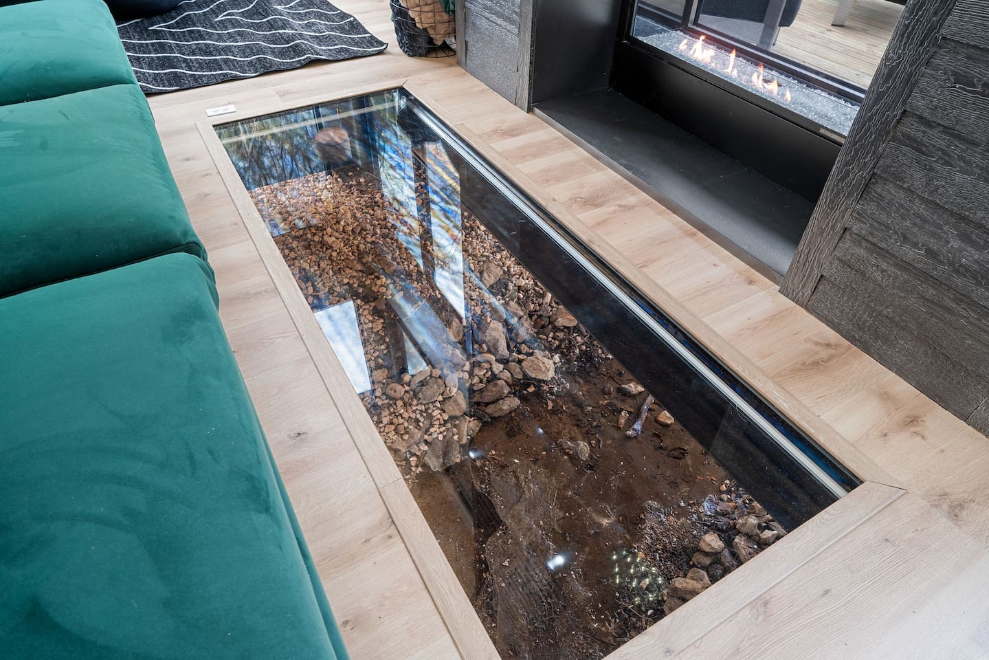 Living Room: Stunning glass floor reveals natural stone and creek flowing underneath for a unique touch!