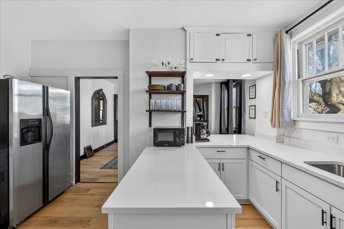 The kitchen also features a large fridge and large windows.